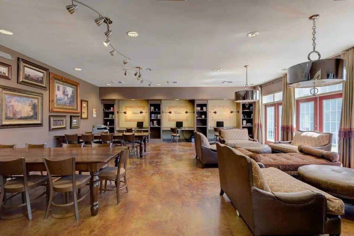 Large table chairs study desks and lounge seating living room at The Grove Apartments Cheney in Cheney Student Accommodation