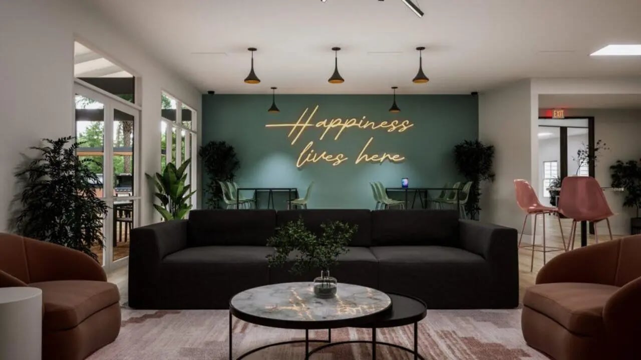 Modern lounge with couches neon sign living room at The Asher in Tallahassee Student Accommodation