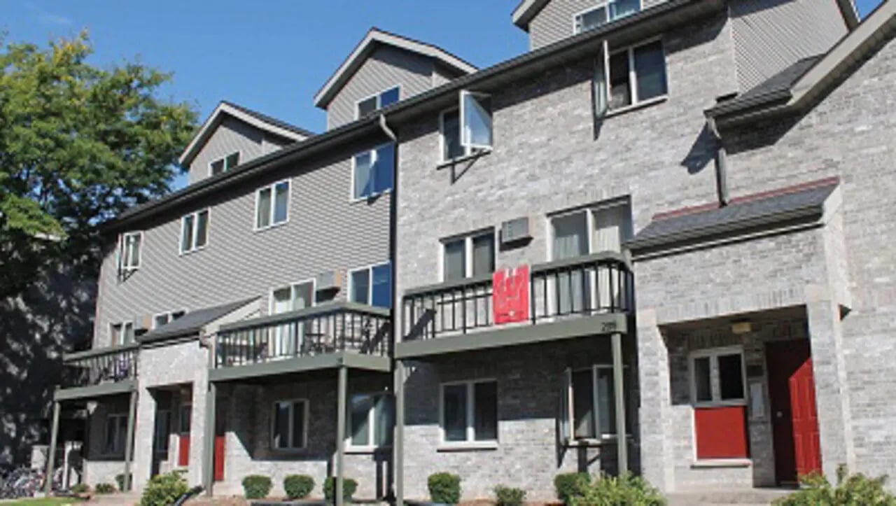 Apartment building with balconies and red doors exterior at College Park Apartments in Ithaca Student Accommodation