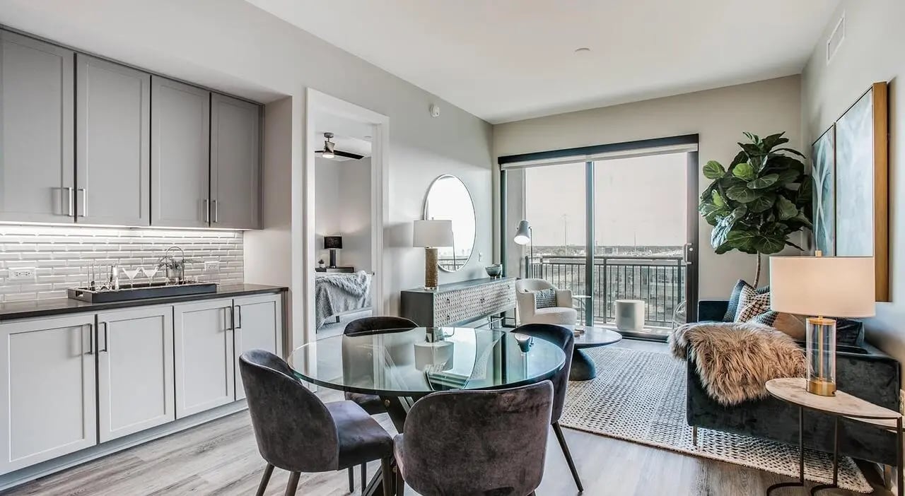 Gray cabinets glass table dark chairs living room at The Flats at Atlantic Station in Atlanta Student Accommodation