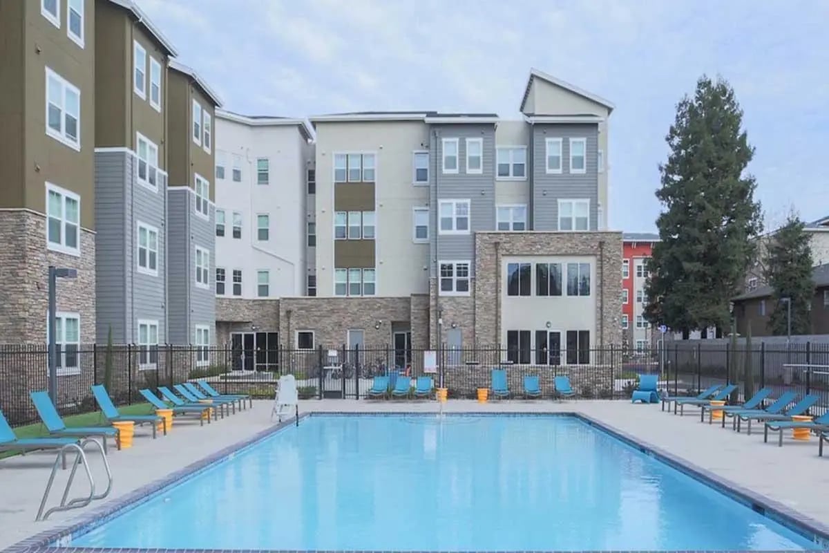 Apartment buildings with pool and lounge chairs exterior at The Post on Nord in Chico Student Accommodation