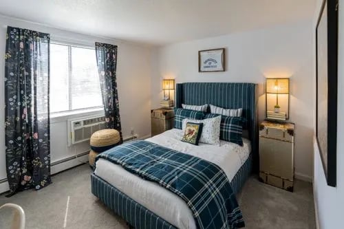 Tartan bed framed by trunks and lamps bedroom at The Den Cedar Ridge in Willington Student Accommodation