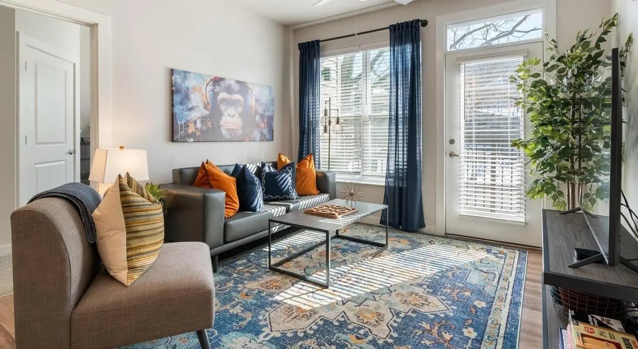 Gray sofa artwork pillows patterned rug living room at The Vanguard in Cincinnati Student Accommodation