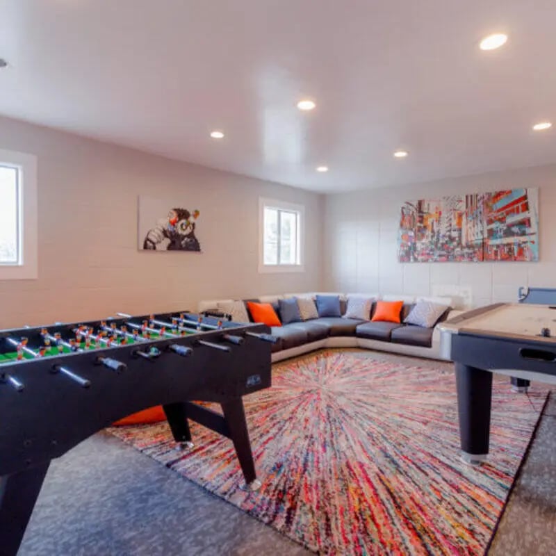 Foosball table sectional sofa colorful rug playing area at Campus Way in Provo Student Accommodation