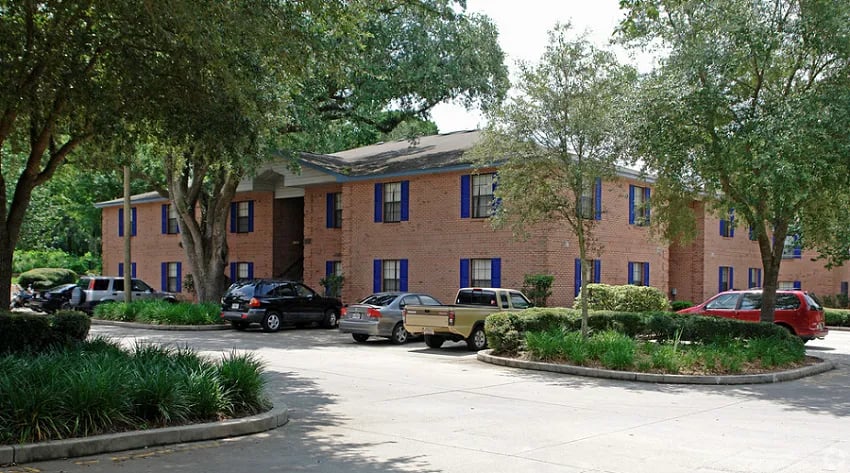 Brick building with blue shutters parking lot exterior at Bradford Oaks Apartments in Tallahassee Student Accommodation