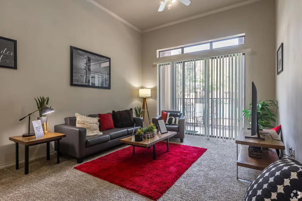 Leather sofa red rug coffee table living room at The Centre Suites in Lubbock Student Accommodation