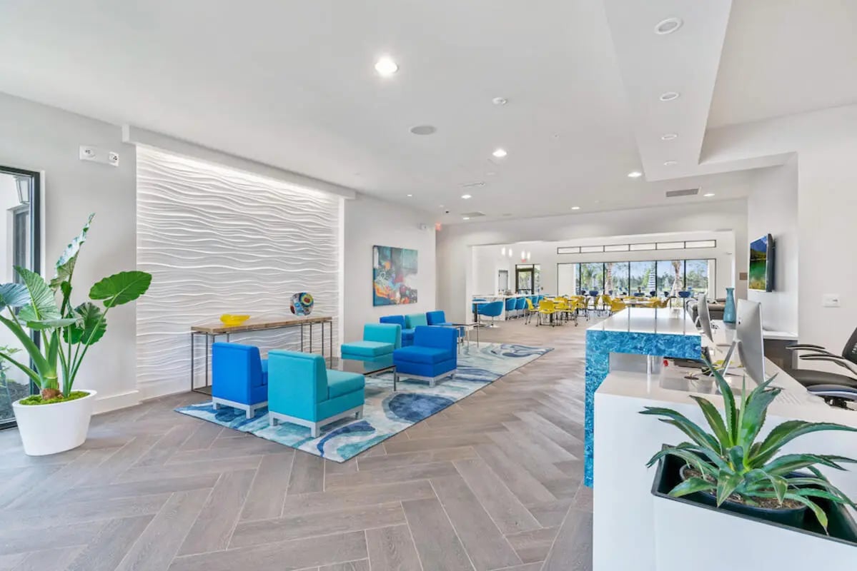 Blue seating desk reception plants living room at The Residences at University Village in Fort Myers Student Accommodation