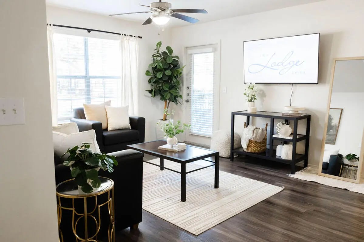 Black sofa coffee table rug and TV living room at The Lodge Apartments in San Marcos Student Accommodation