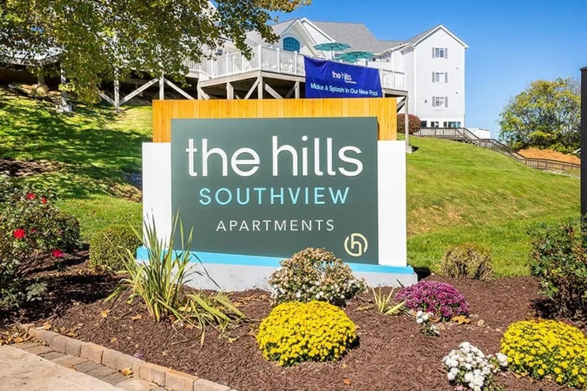 Apartment complex sign with flowers exterior at The Hills Southview Apartments in Harrisonburg Student Accommodation