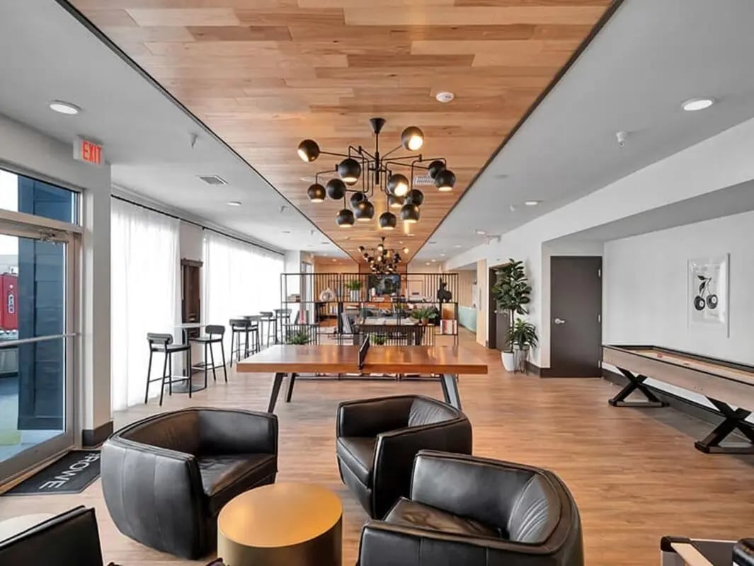 Black chairs ping pong table and bar stools common area at The Rowe Apartments in Tallahassee Student Accommodation