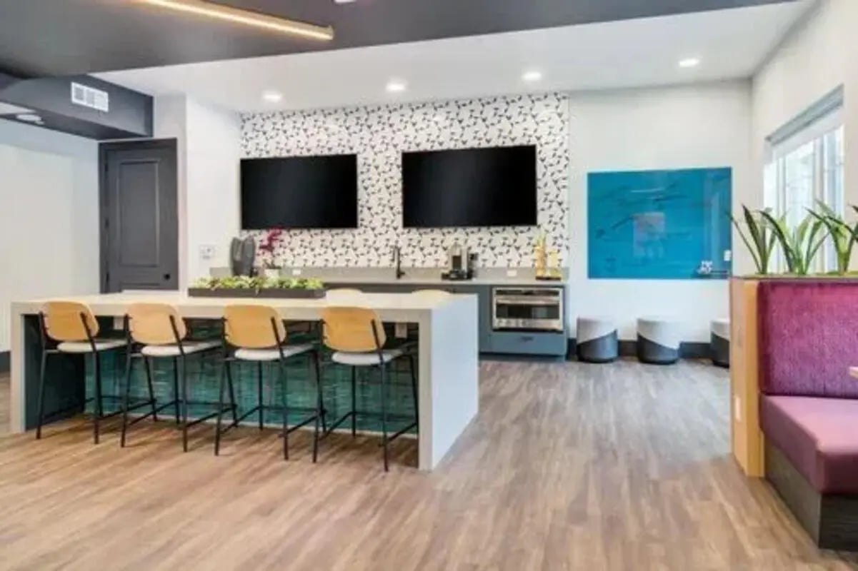 Bar with stools two TVs and modern lounge area at 14 SixtyFive in Kennesaw Student Accommodation