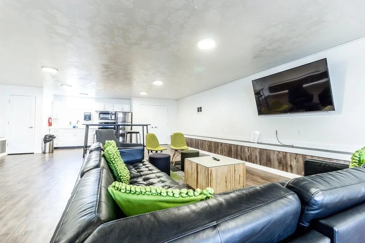 Black leather sectional green pillows coffee table living room at Birch Plaza and Birchwood Apartments in Rexburg Student Accommodation