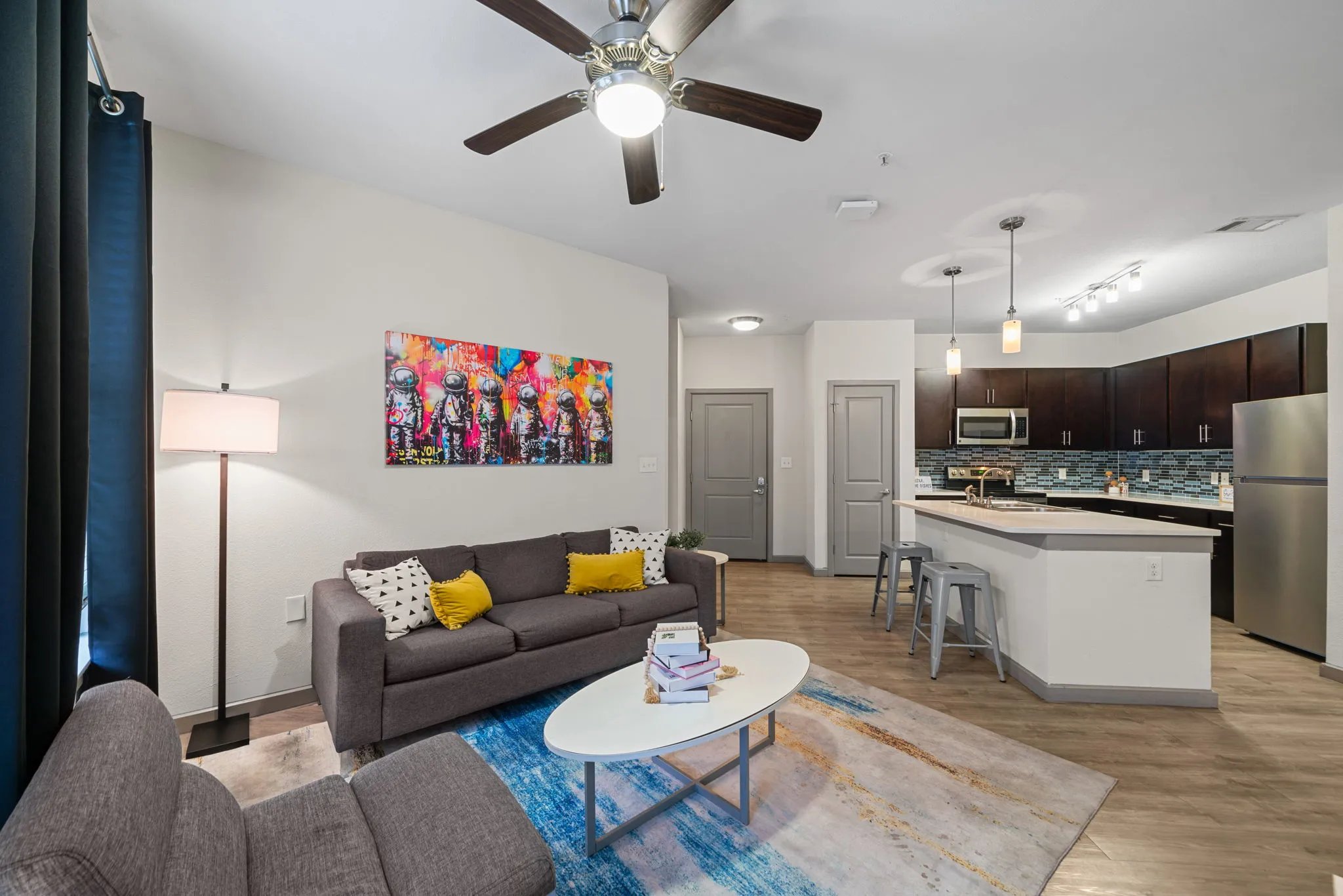 Sofa coffee table rug painting living room kitchen at Altitude Apartments in Houston Student Accommodation