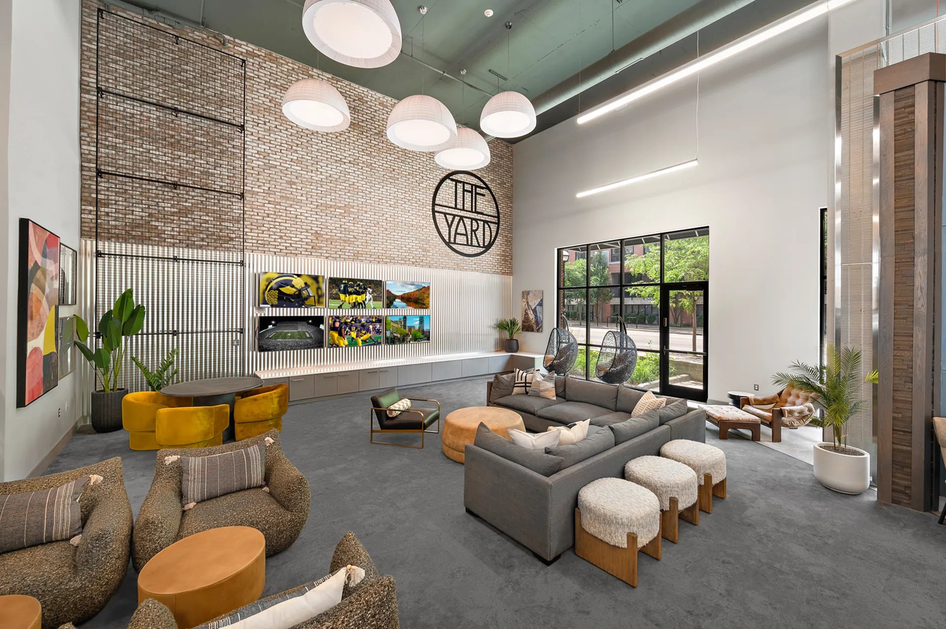 Lounge area with sectional sofa hanging chairs living room at The Yard in Ann Arbor Student Accommodation