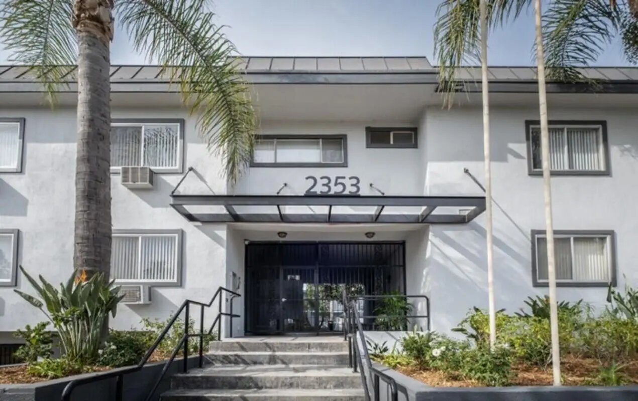 Apartment building exterior with palm trees exterior at USC Student Housing: Heritage 2353 in Los Angeles Student Accommodation