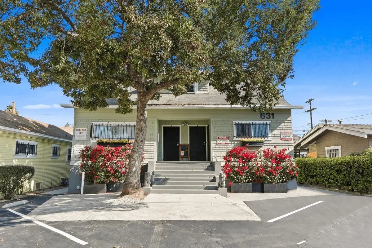 Green building two doors red flowers exterior at USC Student Housing: Heritage 631 in Los Angeles Student Accommodation