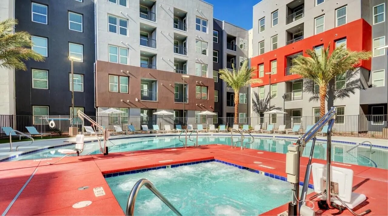Pool area with lounge chairs and palm trees exterior at The Legacy Las Vegas in Las Vegas Student Accommodation