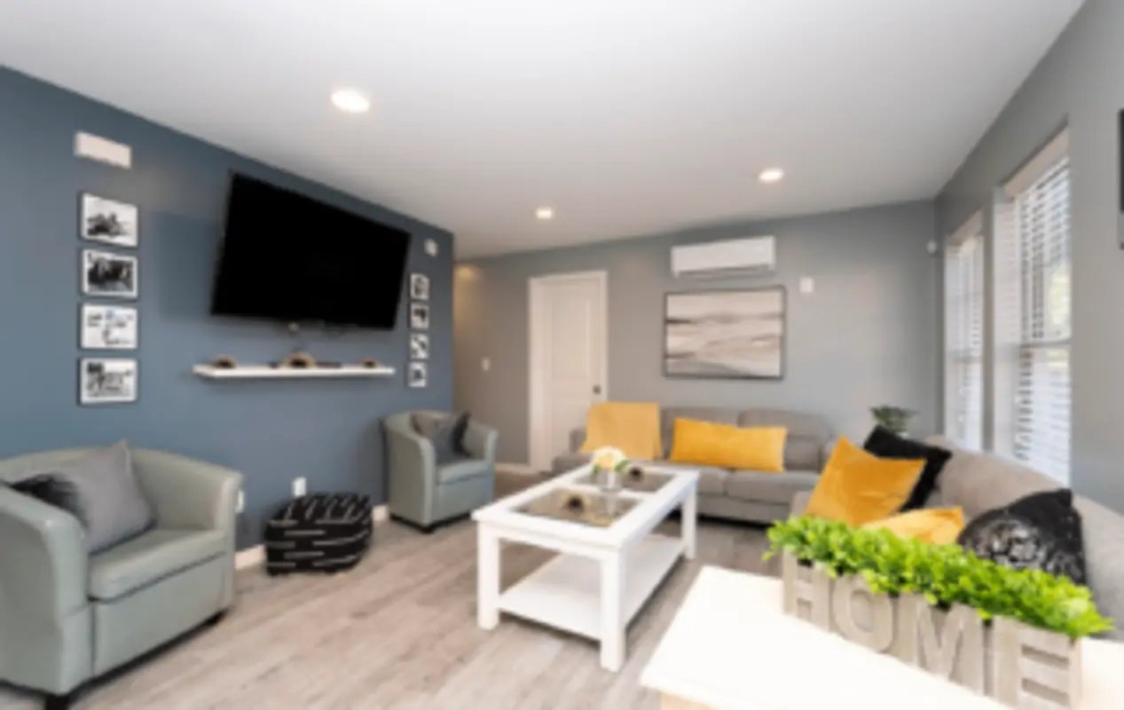 Gray chairs white coffee table sofa living room at Victory Villages in Winston-Salem Student Accommodation