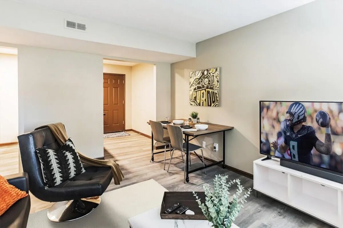 Black chair dining table TV and artwork Living room at Victory on Salisbury in West Lafayette Student Accommodation