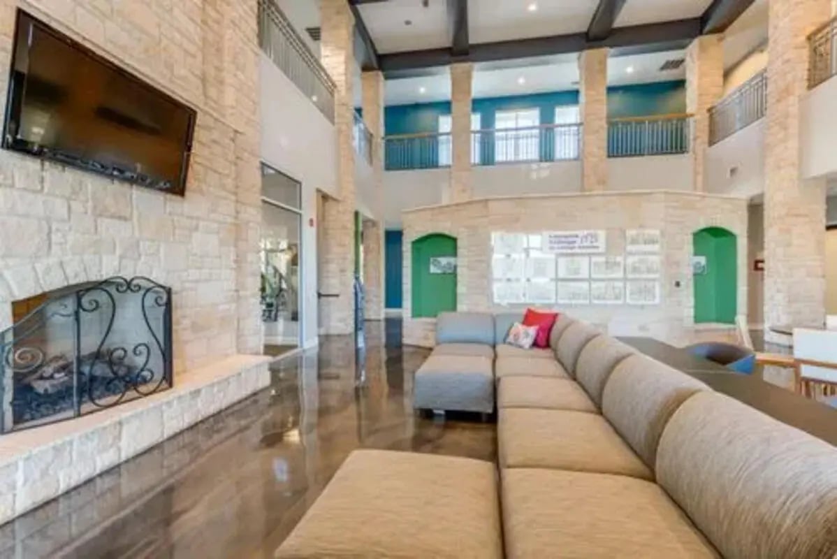 Large sectional sofa television fireplace living room at Campus Village Apartments in College Station Student Accommodation