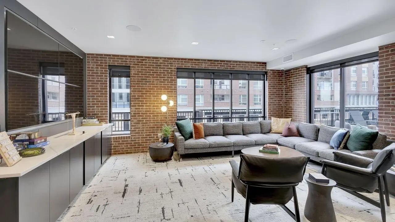 Sectional sofa with pillows coffee table and chairs living room at The Dorsey in Denver Student Accommodation