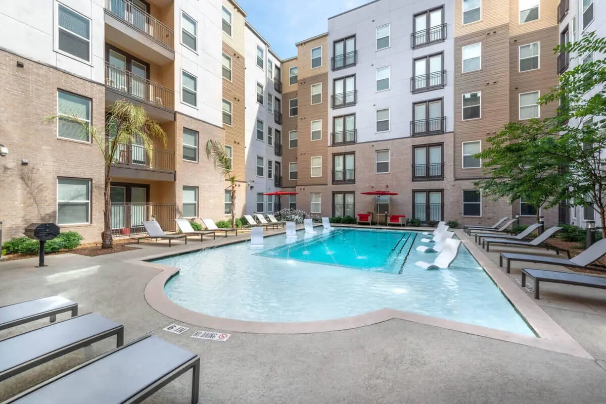 Apartment buildings pool lounge chairs exterior at Campus Vue Apartments in Houston Student Accommodation