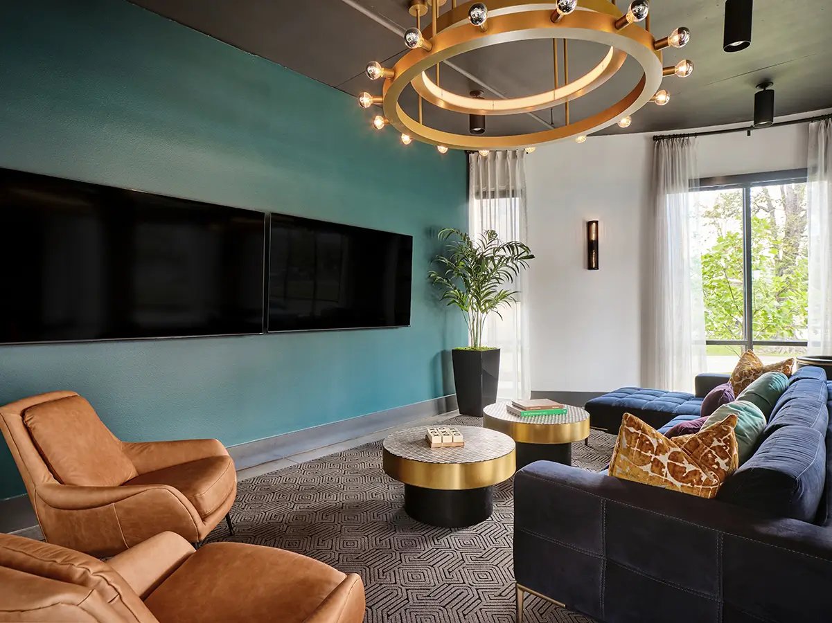 Brown chairs and blue sofas in a lounge living room at Flatiron in Baton Rouge Student Accommodation