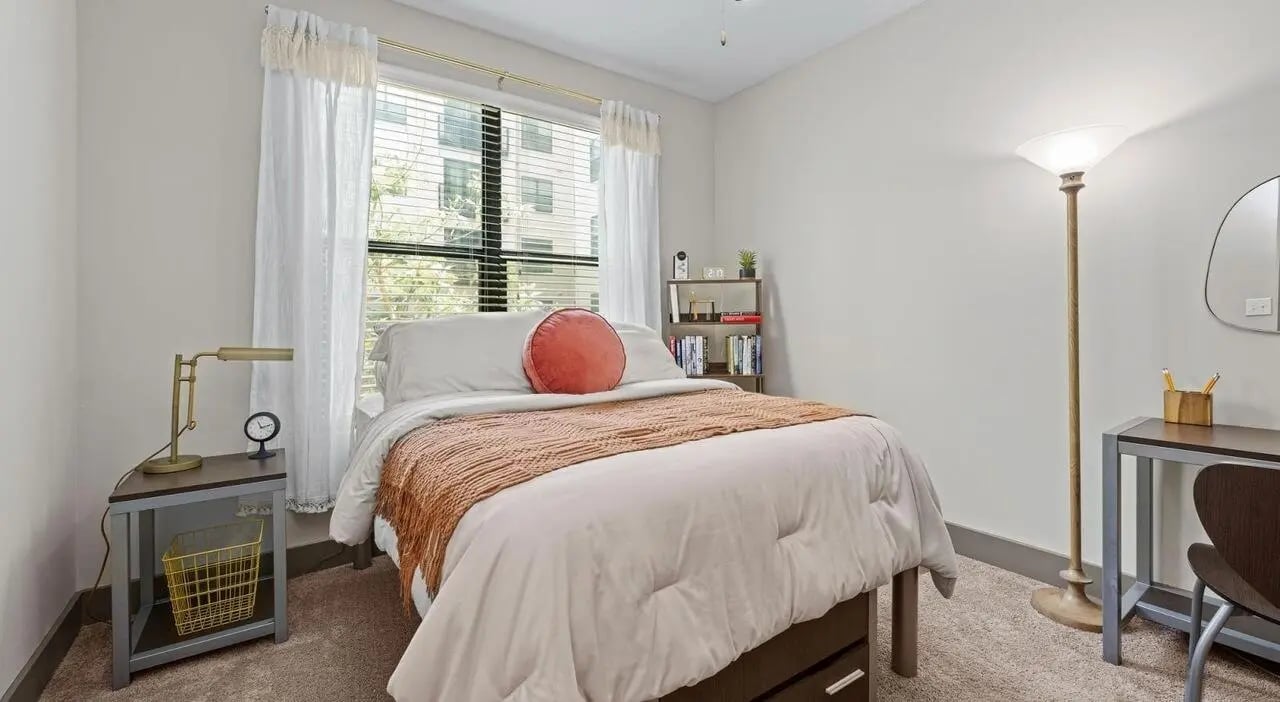 Bed desk lamp bookshelf and pillows bedroom at Accolade Athens in Athens Student Accommodation