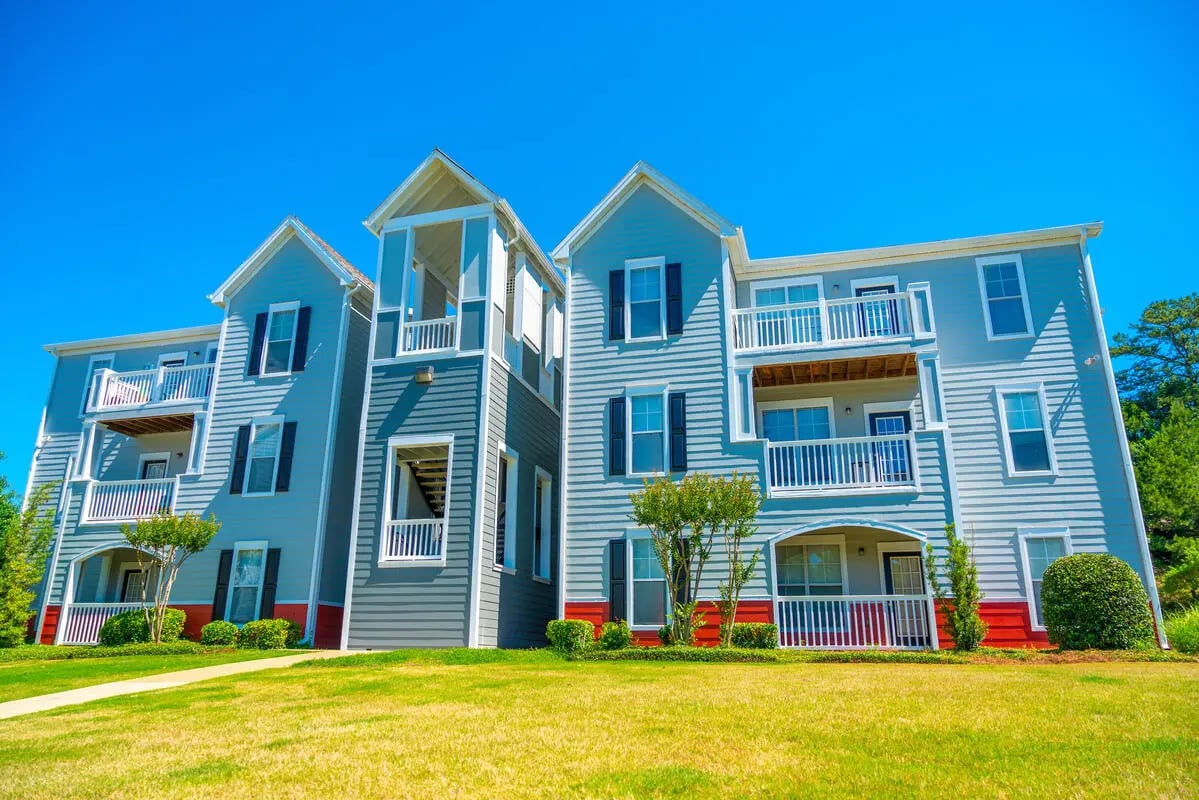 Light blue apartment building with balconies green lawn exterior at Pointe At Troy in Troy Student Accommodation
