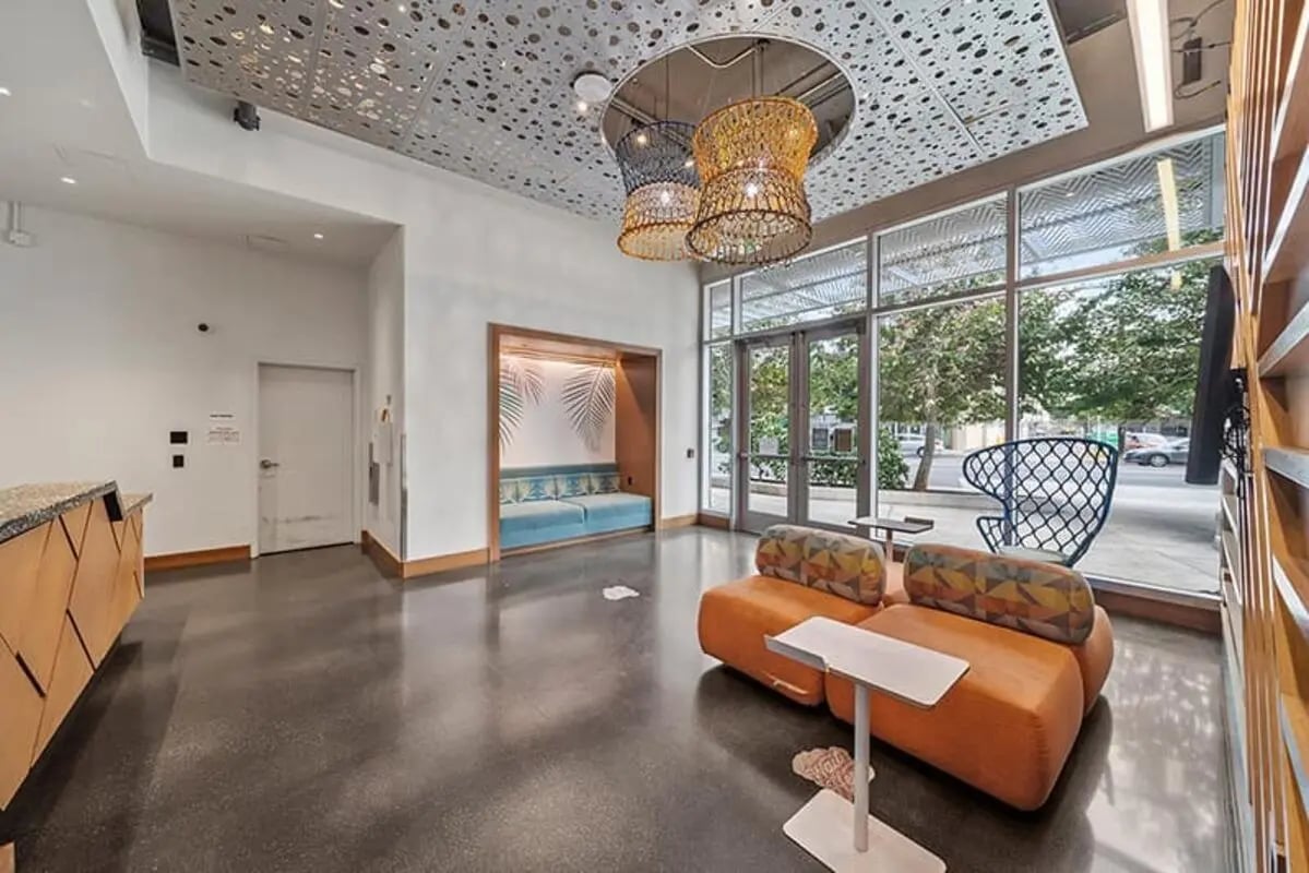 Orange sofa patterned cushions modern reception area living room at Hale Mahana in Honolulu Student Accommodation