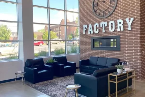 Black leather seating fireplace brick wall living room at The Factory Student Housing in Logan Student Accommodation