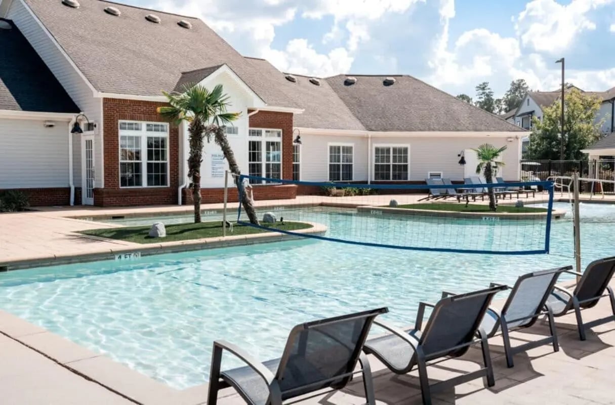 Swimming pool with chairs and volleyball net exterior at Lakeside Student Living in Starkville Student Accommodation