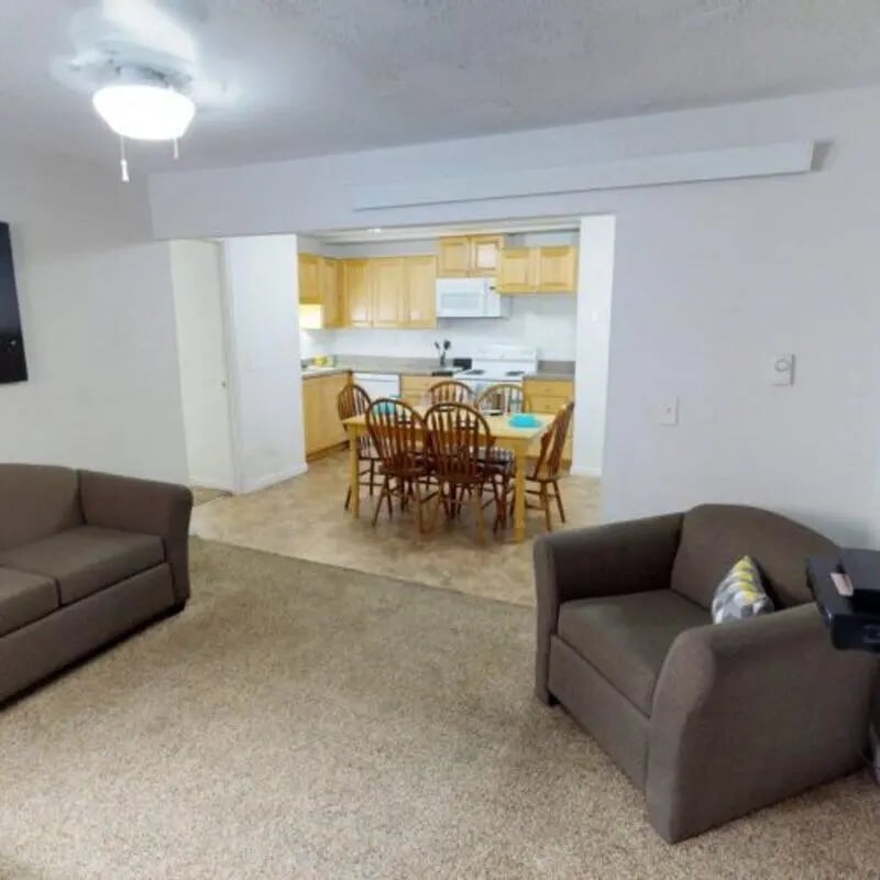 Two sofas dining table kitchen area living room at The Pines in Rexburg Student Accommodation