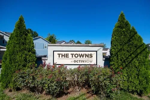 The Towns at OctivRow sign with greenery exterior at The Towns at Octiv Row in Carrollton Student Accommodation