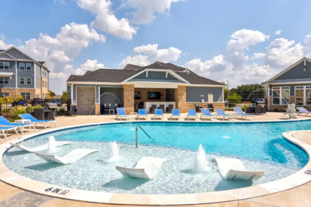 Pool with lounge chairs and building exterior at Stadium View in Ames Student Accommodation