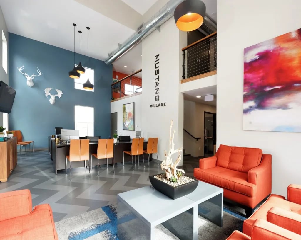 Reception desk with orange chairs modern seating living area at Mustang Village Apartments in San Luis Obispo Student Accommodation