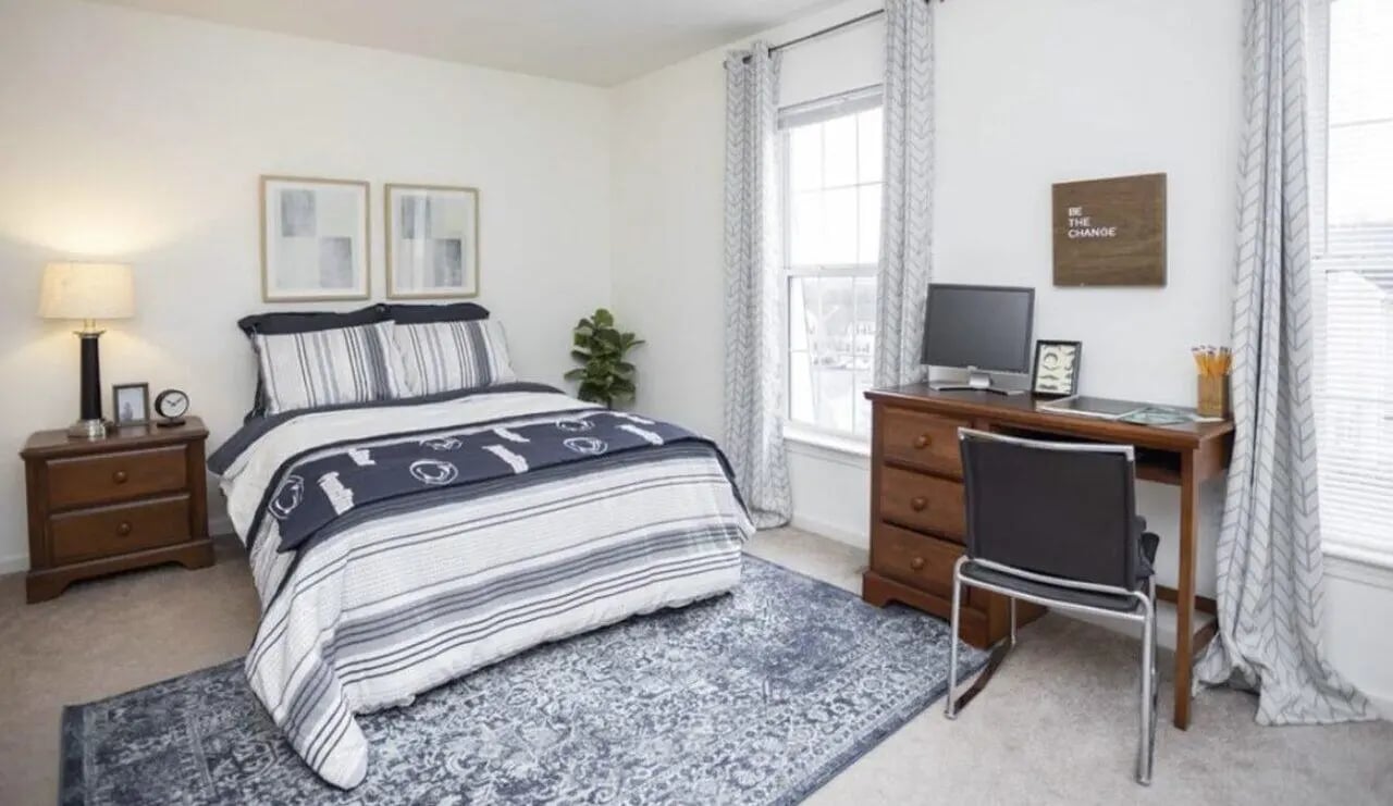 Bed nightstand desk computer and chair bedroom at State College Collective Apartments in State College Student Accommodation