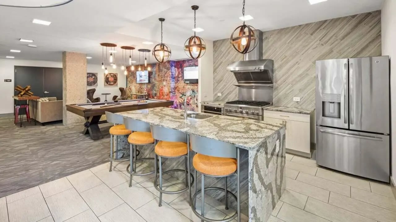 Island kitchen with bar stools pool table living area at Varsity on K Apartments in Washington Student Accommodation