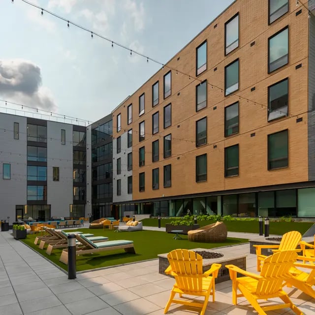 Yellow chairs lounge chairs fire pit courtyard exterior at 505 on Walnut Apartments in Syracuse Student Accommodation