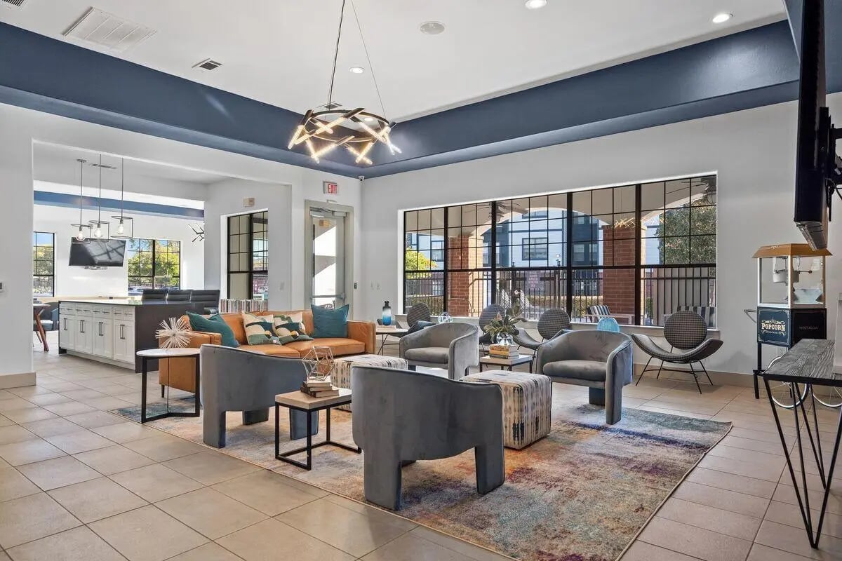 Modern lounge with sofas armchairs and popcorn machine living room at Midtown 905 in Denton Student Accommodation
