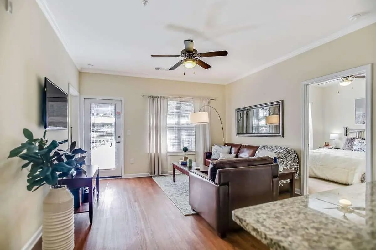 Sofa TV plant and bedroom visible living room at West 22 in Kennesaw Student Accommodation