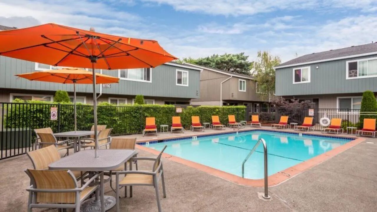 Swimming pool with lounge chairs and umbrellas pool area at Curry Court Apartments in Portland Student Accommodation