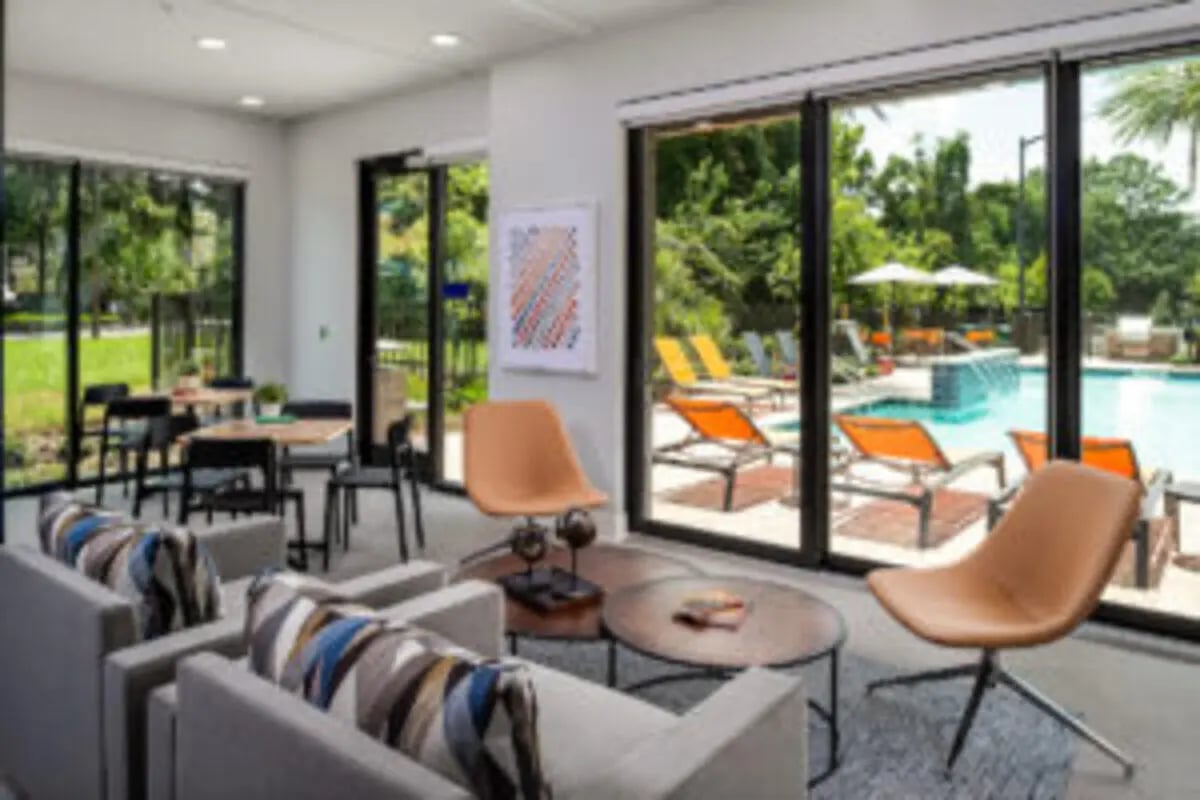 Seating area with sofas tables chairs swimming pool lounge chairs outdoor area at Anthem House in Gainesville Student Accommodation
