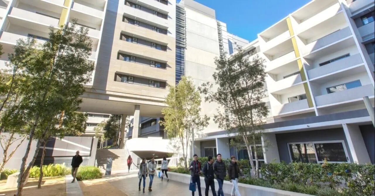 Modern apartment buildings with trees and people exterior at Centennial in Arlington Student Accommodation