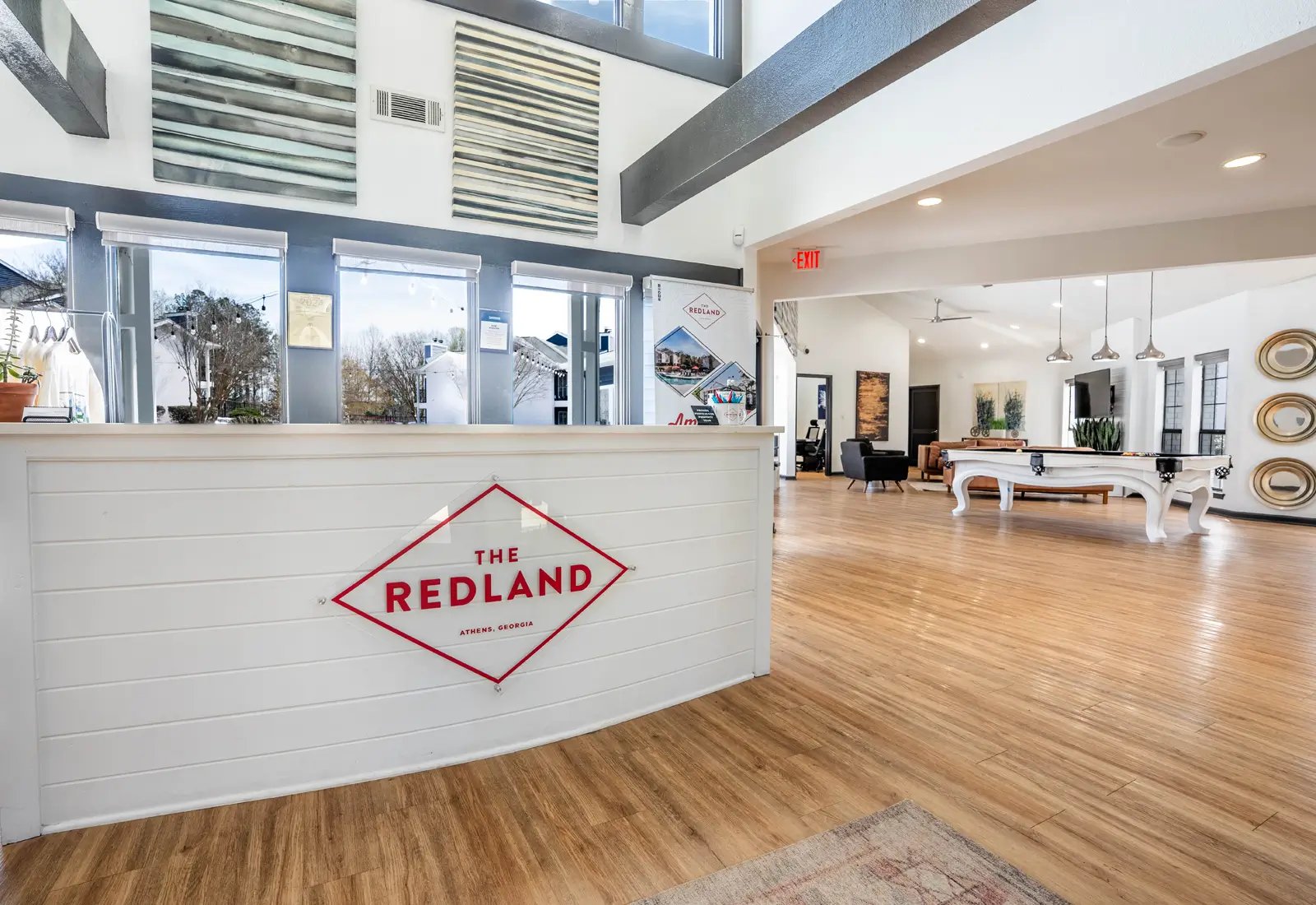 Reception desk with Redland logo game room living area at The Redland Apartments in Athens Student Accommodation