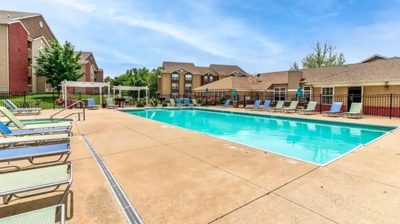 Chairs and pool next to apartment buildings swimming pool at 900 on Park Apartments in Carbondale Student Accommodation