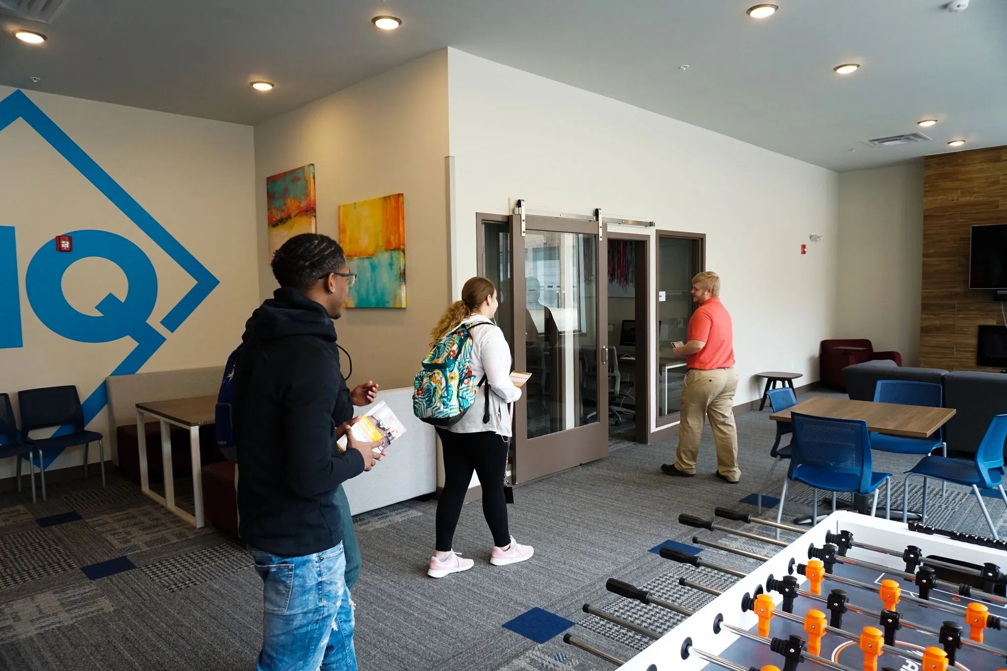 Modern common area with foosball table and seating living room at Highland Quarters in Terre Haute Student Accommodation