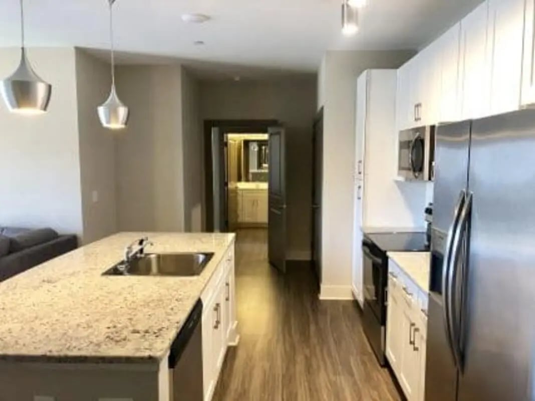 Kitchen island sink cabinets refrigerator microwave kitchen at Plaza One 89 in Clemson Student Accommodation