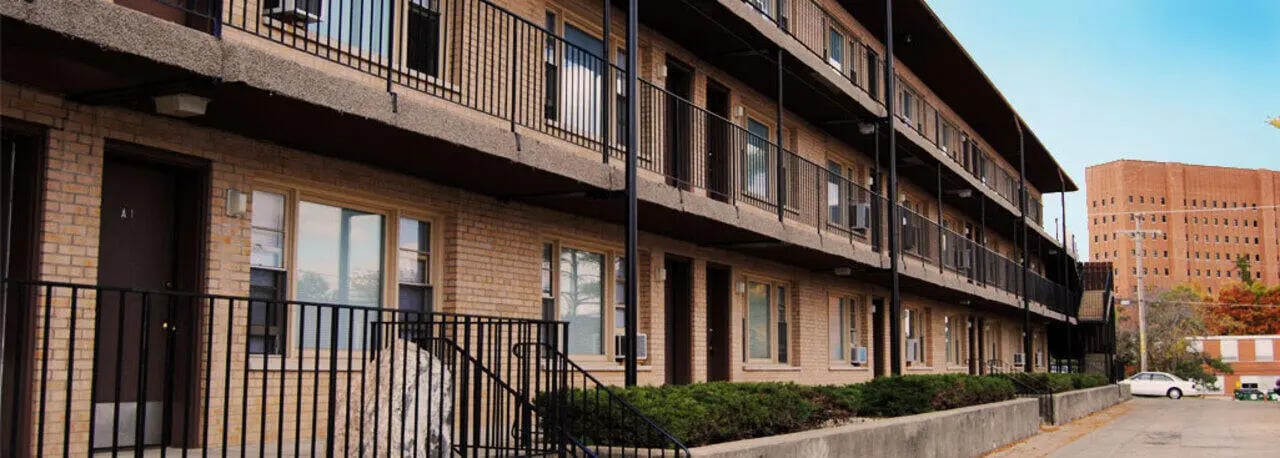 Brick apartment building with balconies and windows exterior at Cardinal Apartments in DeKalb Student Accommodation