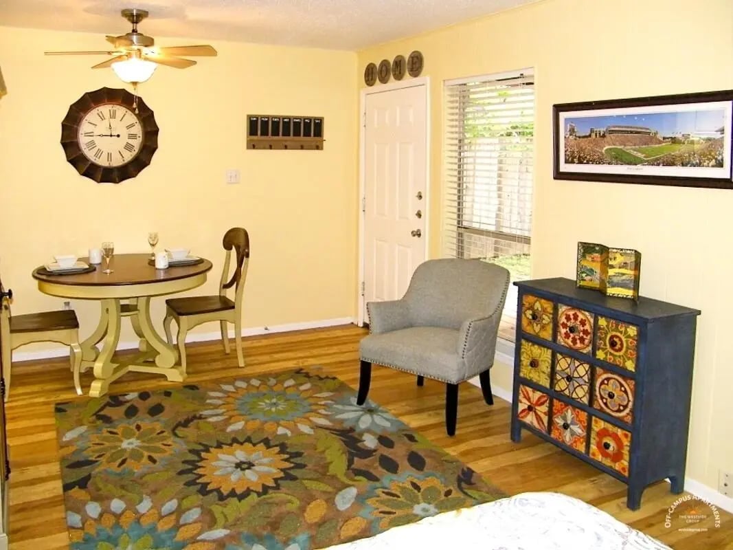 Dining table chairs rug grey armchair patterned dresser living room at Barranca Square Student Apartments in Austin Student Accommodation